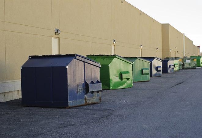 a row of yellow and blue dumpsters at a construction site in Bowmanstown